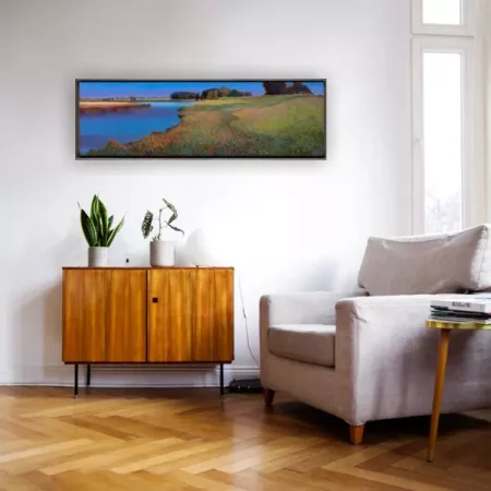 Het giclee Aan de oever van het Reitdiep van Ton Dubbeldam ingelijst aan de wand in een huiskamer